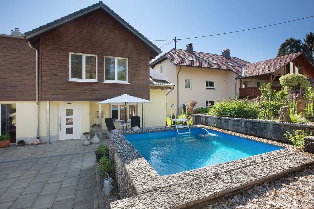 a swimming pool in the backyard of a house at Quellenhof Südschwarzwald in Murg