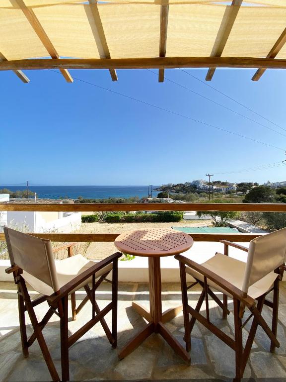 dwa krzesła i stół na patio z widokiem w obiekcie Agnadi Syros Beachfront Studios & Rooms w mieście Megas Gialos - Nites