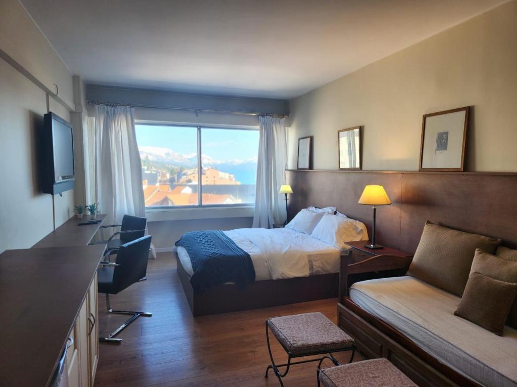 Habitación de hotel con cama y ventana en Buena Vista en San Carlos de Bariloche
