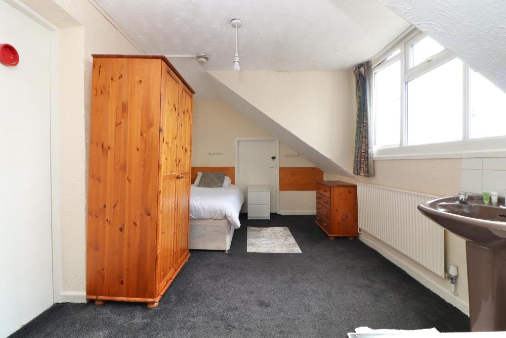 1 dormitorio con 1 cama y lavamanos en una habitación en Pebbles Guest House en Southampton