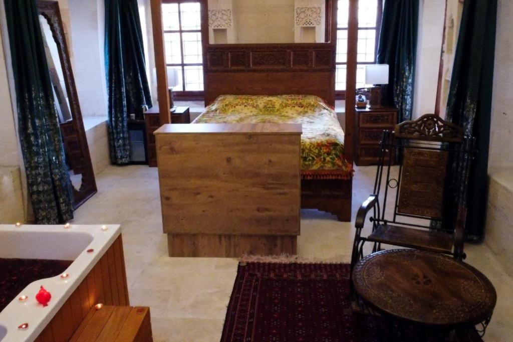 Schlafzimmer mit einem Bett, einer Kommode und einem Schreibtisch in der Unterkunft Hercai Butik Otel in Midyat
