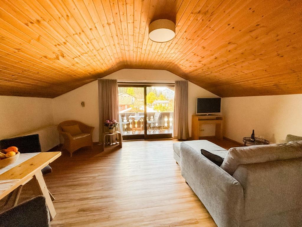 ein Wohnzimmer mit einem Sofa und einem Tisch in der Unterkunft Gästehaus Kayetan in Klais