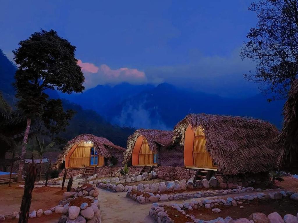 a group of huts in the mountains at night at Nhà Tổ Ong in Lai Châu