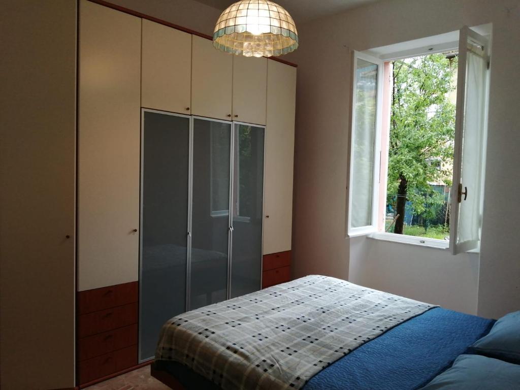 a bedroom with a bed and a window and a chandelier at Domo Nina in La Spezia