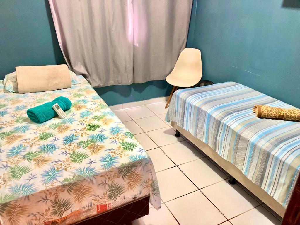 a room with two twin beds and a chair at Apartamento Imp 1 - Bosque 1 in Imperatriz