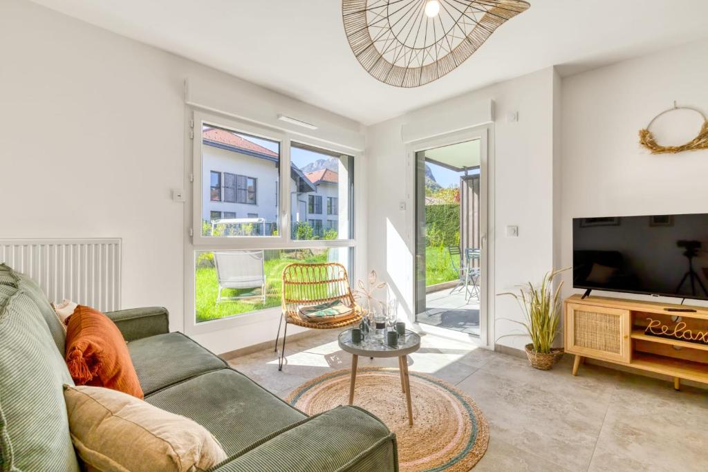 un salon avec un canapé et une télévision dans l'établissement La Caseta - idéalement situé à 150m du lac, à Duingt