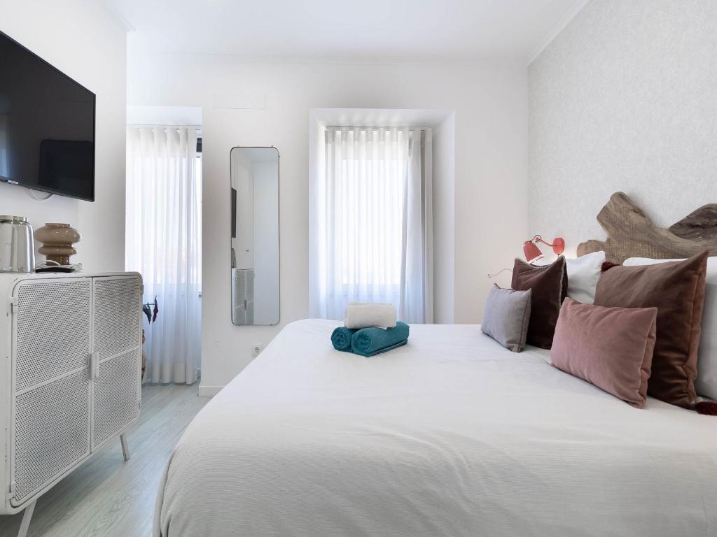 sypialnia z dużym białym łóżkiem z kolorowymi poduszkami w obiekcie Akicity Ajuda Fort w Lizbonie