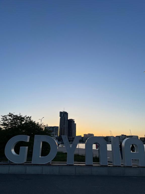 a sign for gdynia with a city in the background at Gdynia Riviera Hills in Gdynia