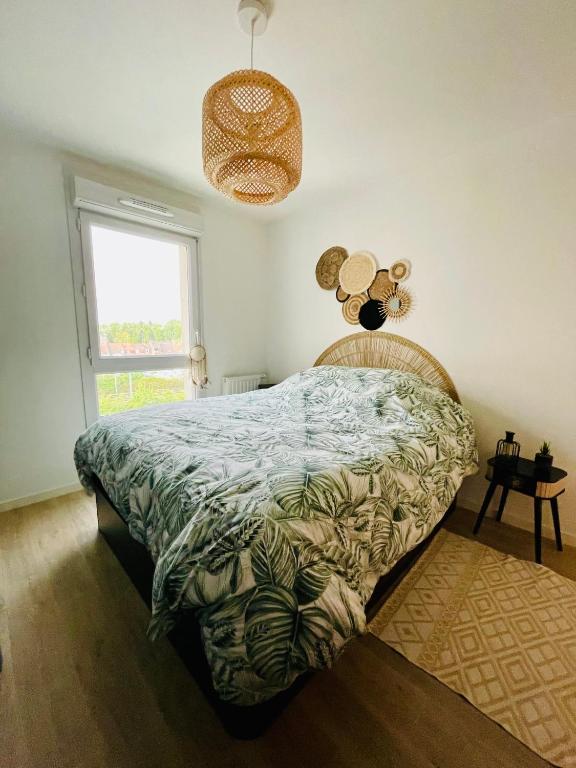 - une chambre avec un lit doté d'une couette verte et d'une fenêtre dans l'établissement Chez André - Appartement 4 personnes prox Lille, à Saint-André