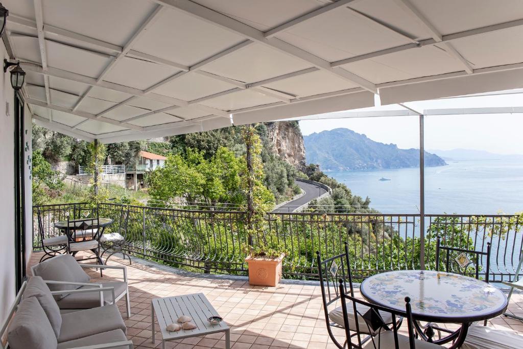 patio con sedie, tavoli e vista sull'acqua di Casa Giosuè - Your home on the Amalfi Coast a Conca dei Marini