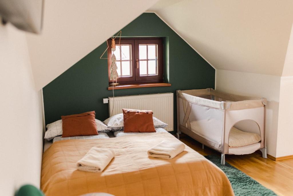 sypialnia z łóżkiem i zieloną ścianą w obiekcie Willa Radosna w Szczyrku