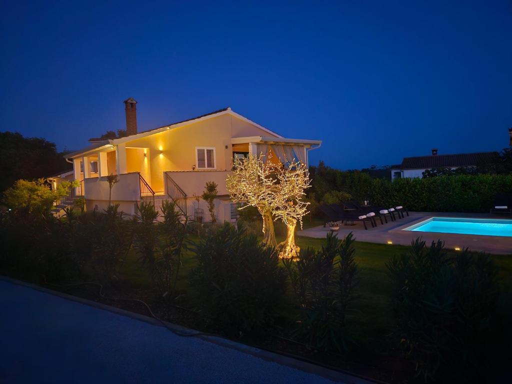 een huis met een boom voor een zwembad bij Residence David in Poreč