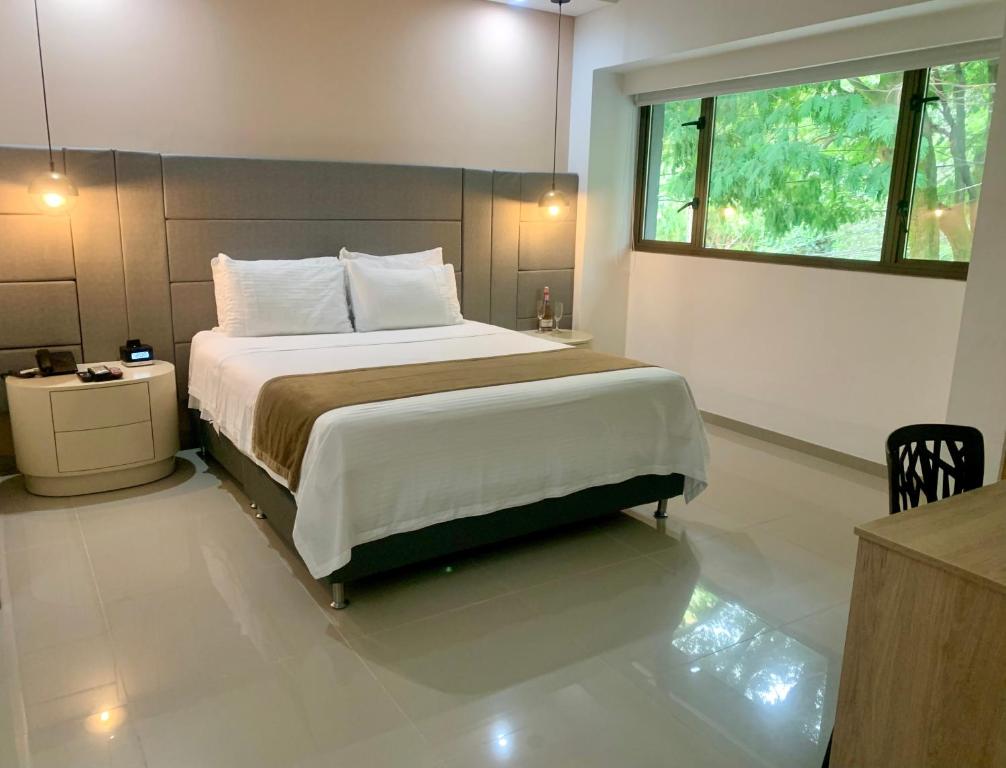 sypialnia z dużym łóżkiem i oknem w obiekcie Hotel Zona A w mieście Medellín