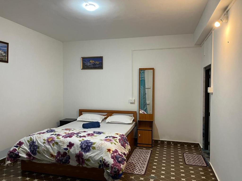 um pequeno quarto com uma cama e um espelho em Pradhan Homestay Mirik - Homestay beside Mirik Lake em Mirik