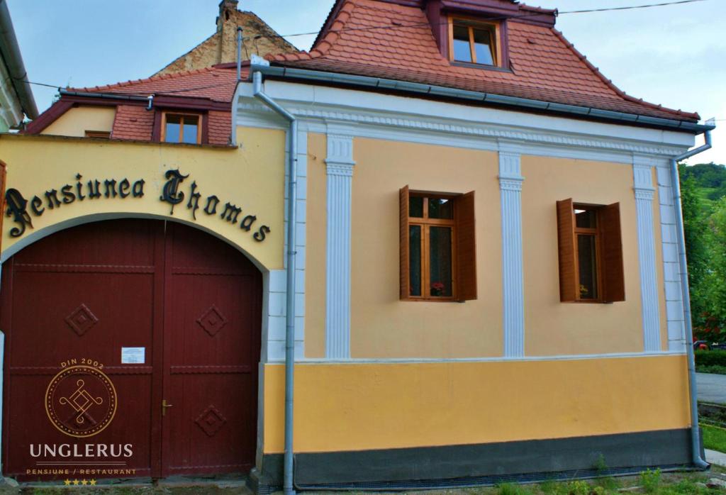 a building with a garage in front of it at Thomas Guesthouse in Biertan