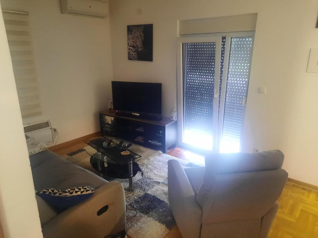 a living room with a couch and a television at Leo in Surčin