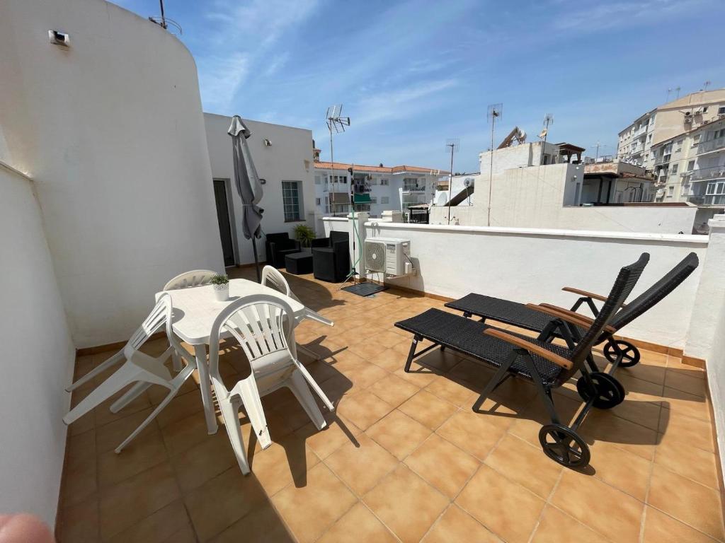 een balkon met een tafel en stoelen op een dak bij Apartamento Centro de Nerja in Nerja
