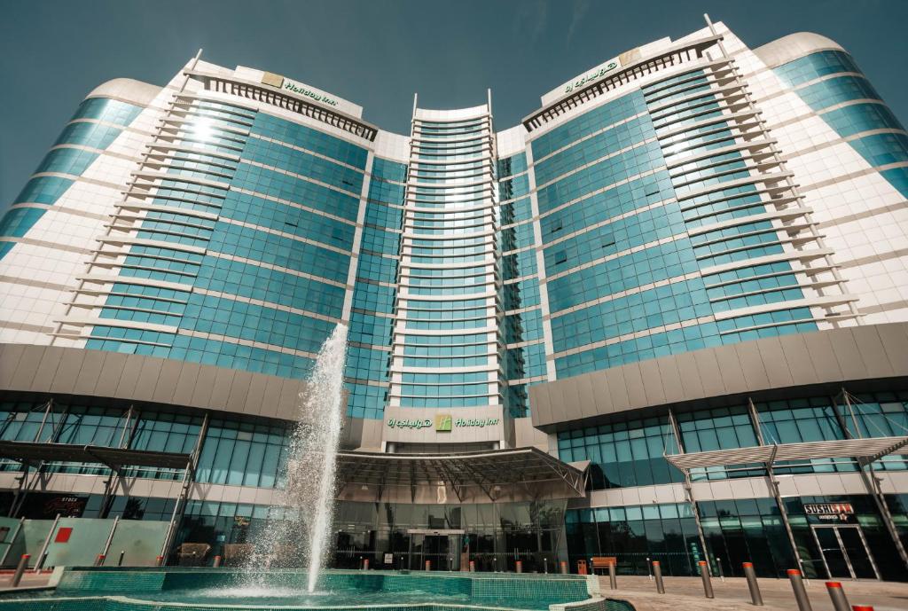 two tall buildings with a fountain in front of them at Holiday Inn Abu Dhabi, an IHG Hotel in Abu Dhabi