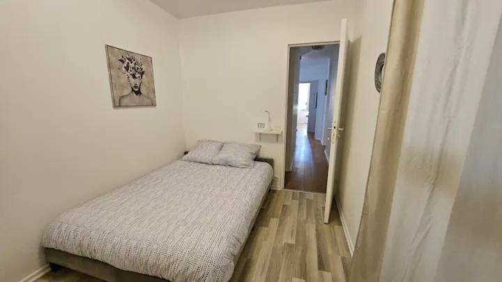 um pequeno quarto com uma cama e um corredor em Ruby room - 20 min to Paris em Créteil