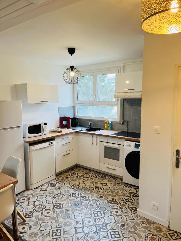 une petite cuisine avec des appareils électroménagers blancs et une table dans l'établissement Fontaine blanche Besançon, à Besançon