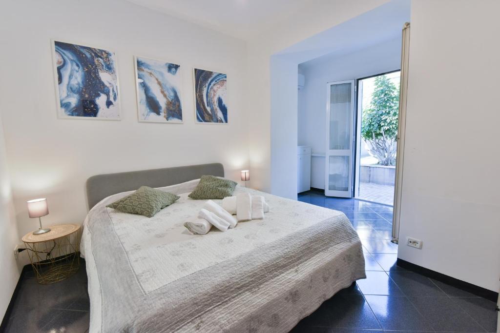 a white bedroom with a large bed with two pillows at Welcome Varigotti - Civico53 in Varigotti