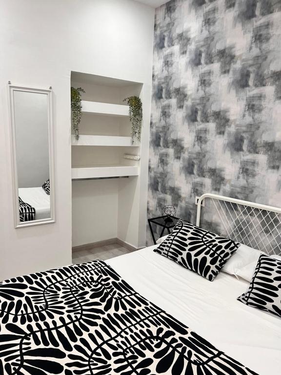 Un dormitorio con una cama en blanco y negro y un espejo en Costantino Home, en Pompeya