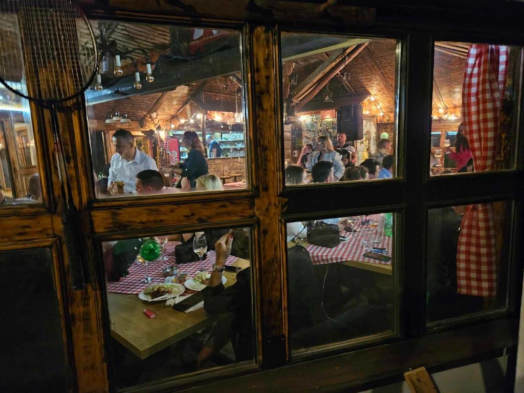 un gruppo di persone seduti a un tavolo in un ristorante di Čarda kod Mike a Futog