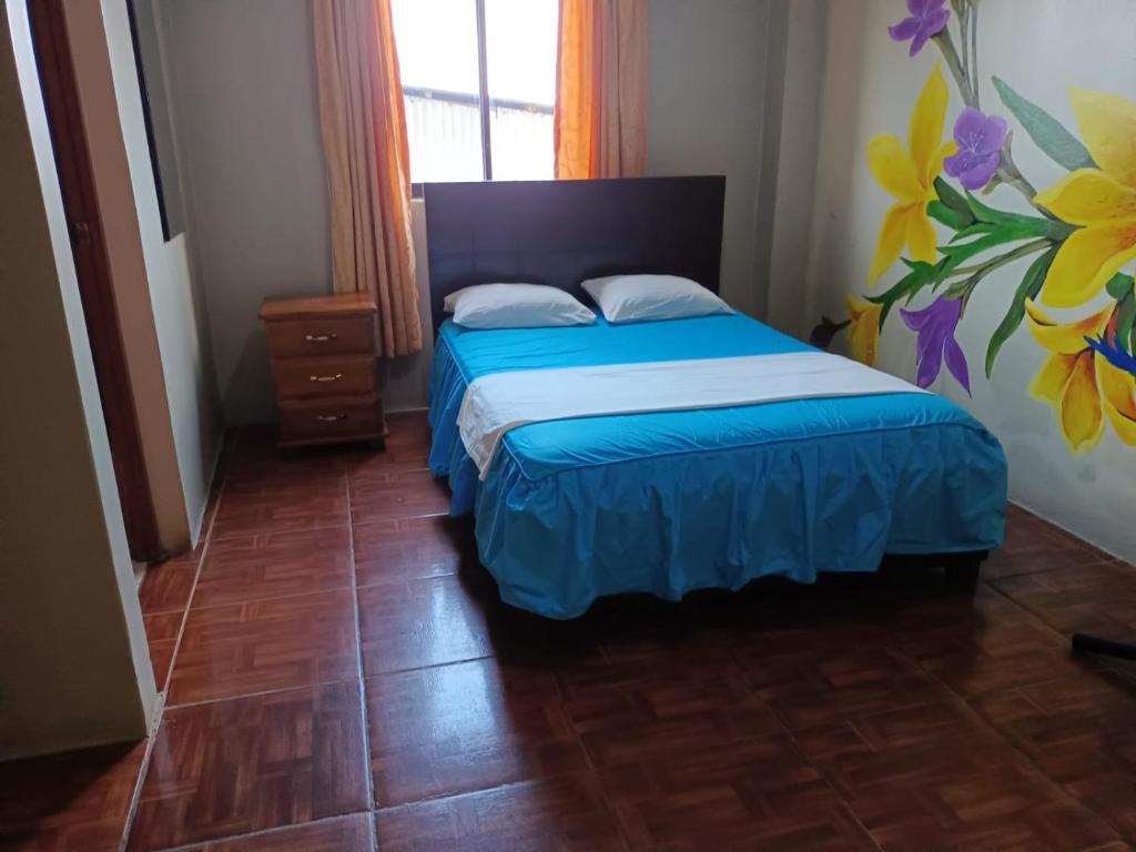 1 dormitorio con 1 cama con colcha azul en Hospedaje el Emperador, en Pucallpa