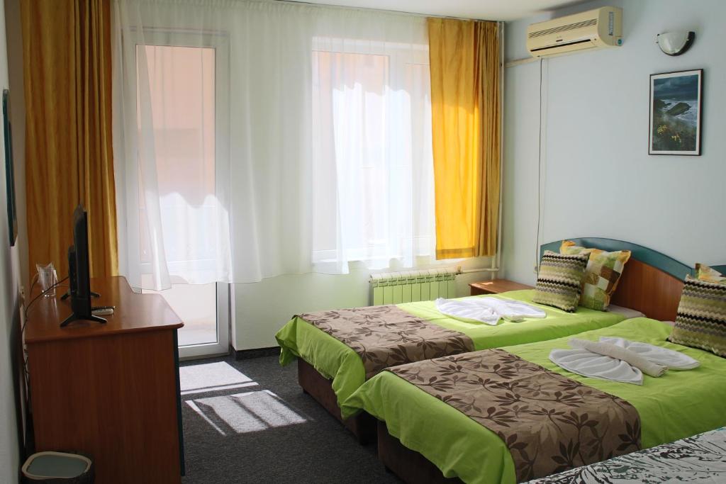 Habitación de hotel con 2 camas y TV en Guest House Elit en Burgas