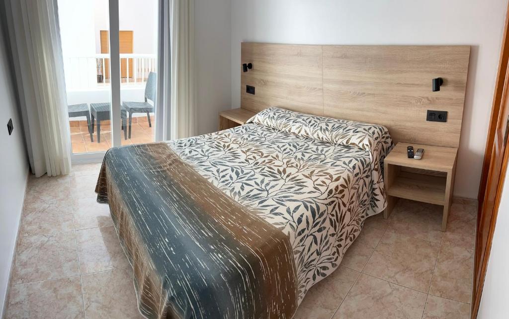 a bedroom with a bed with a wooden head board at Hostal Juan Carlos in Carboneras