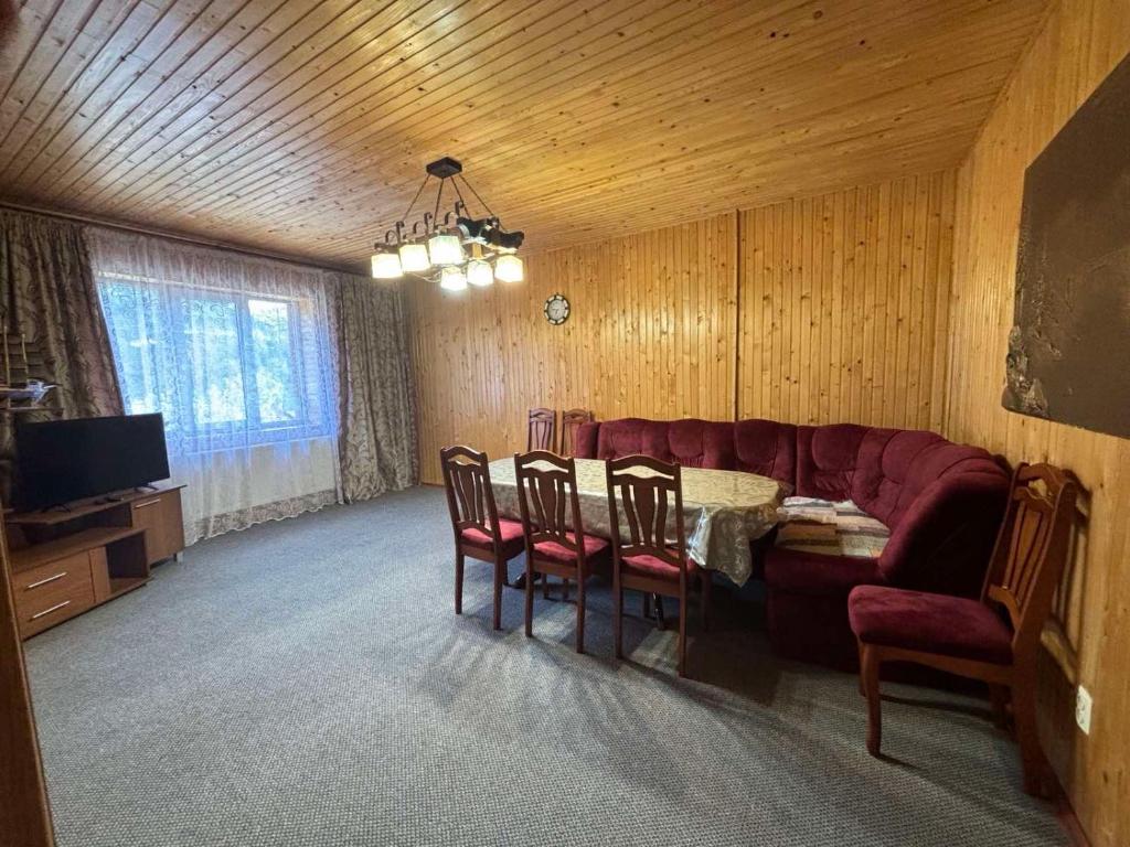 salon z kanapą, stołem i krzesłami w obiekcie САДИБА та ЧАН "NA PAGORBI" w Jaremczach