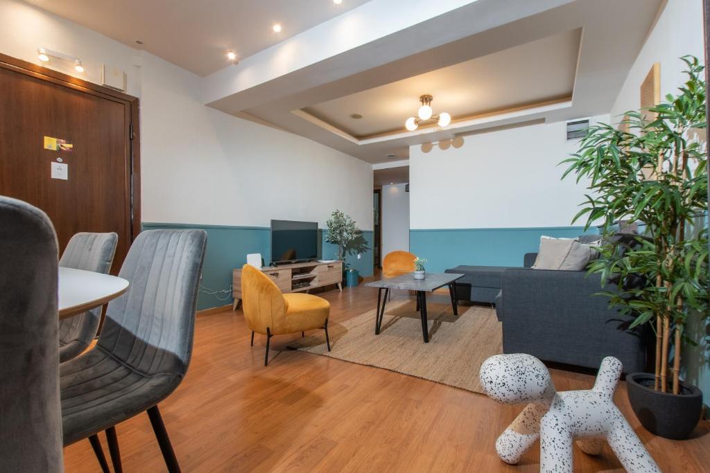 een woonkamer met een bank en een tafel en stoelen bij Houseloft Cosmopolitan Comfort in Thessaloniki