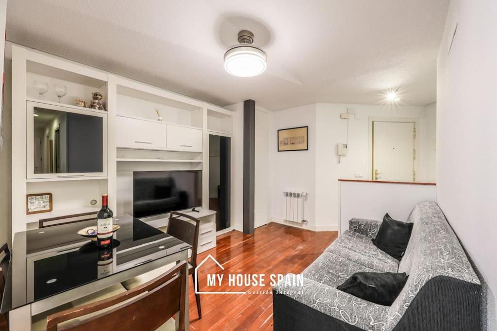 a living room with a couch and a table and a tv at MyHouseSpain - Tranquilo piso cerca de Sol in Madrid