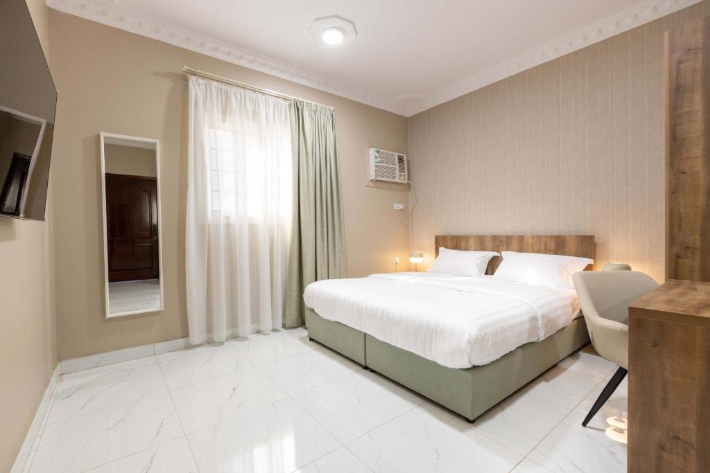 a bedroom with a large bed and a window at Al-Rajhi Luxury Modern Flats - Nozol Noor 6 in Al Madinah