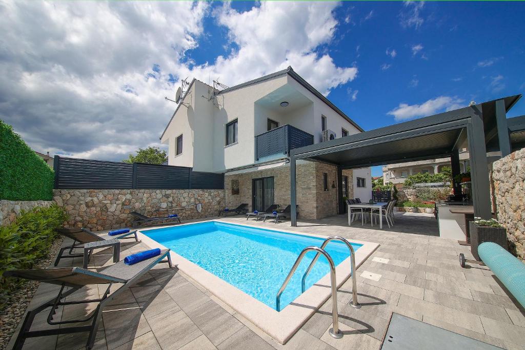 a swimming pool in the backyard of a house at Holiday house ZOROO with private pool in Sveti Anton