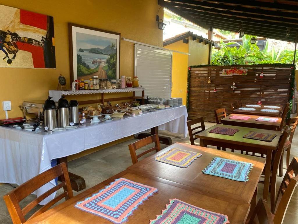 cocina con mesa y 2 mesas y sillas en Pousada Casa Hospedaria, en Paraty