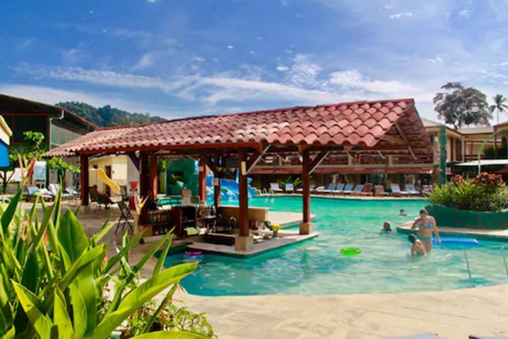 un grupo de personas en una piscina en un complejo en Amapola Resort, en Jacó