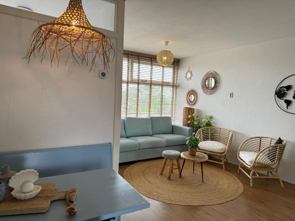 - un salon avec un canapé bleu et une table dans l'établissement die Perle, à Zandvoort