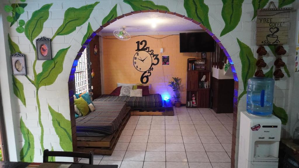 a room with an archway with a bed and a clock at Pool House Hostel in Santa Ana