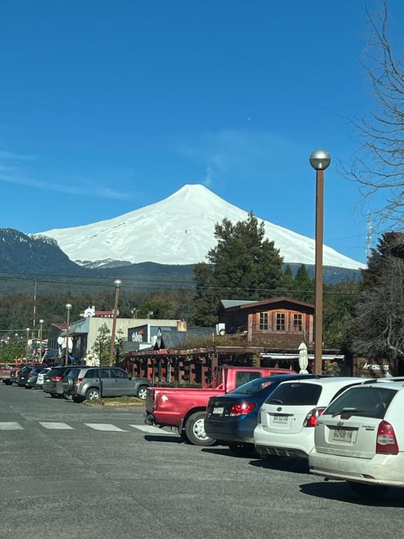 a parking lot with a snow covered mountain in the background at Departamento en Pucón Familiar para 7 personas vista Volcán Villarrica 4 dormitorios 3 baños in Pucón