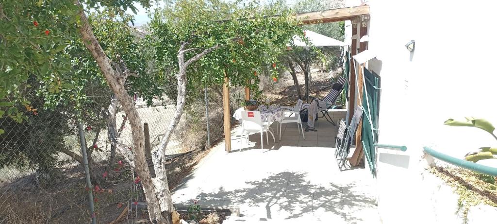 un porche de una casa con mesa y sillas en Los Roblecillos, en Pechina