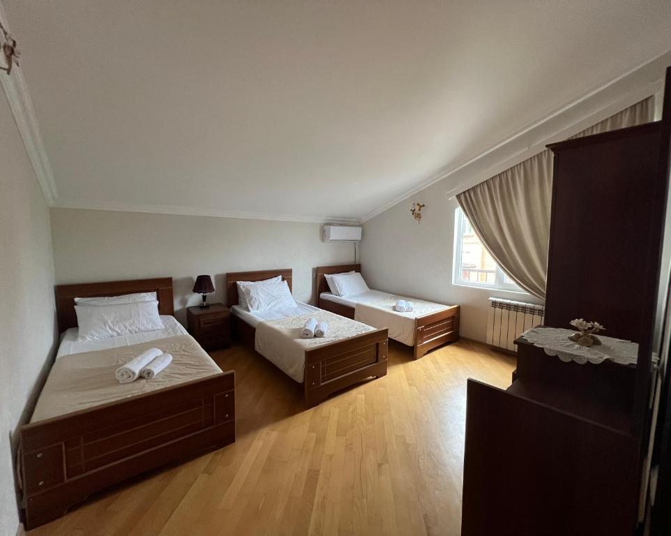 a small room with two beds and a window at Guesthouse Emilya in Kutaisi