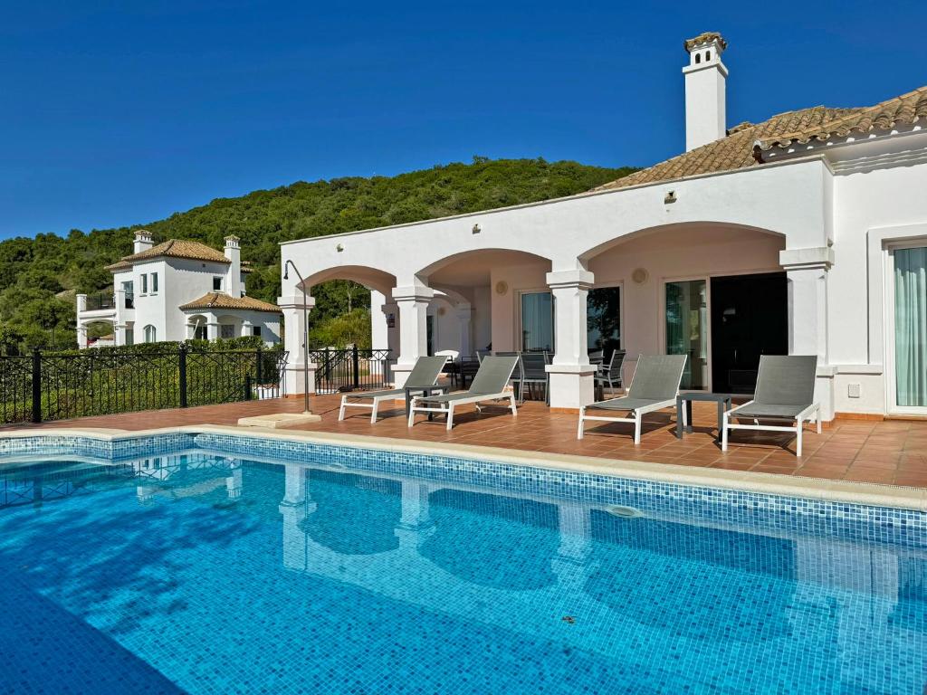 a swimming pool with chairs and a house at Villa Los Olivos - Ole Solutions in Arcos de la Frontera