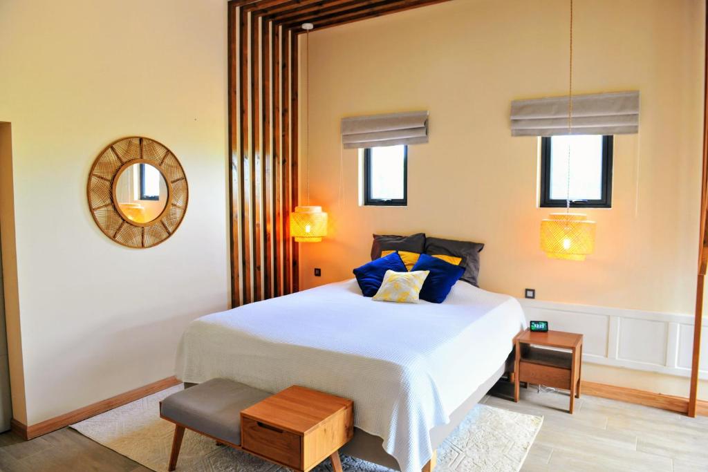 um quarto com uma grande cama branca com almofadas azuis em Golf View Villa em Roches Noires