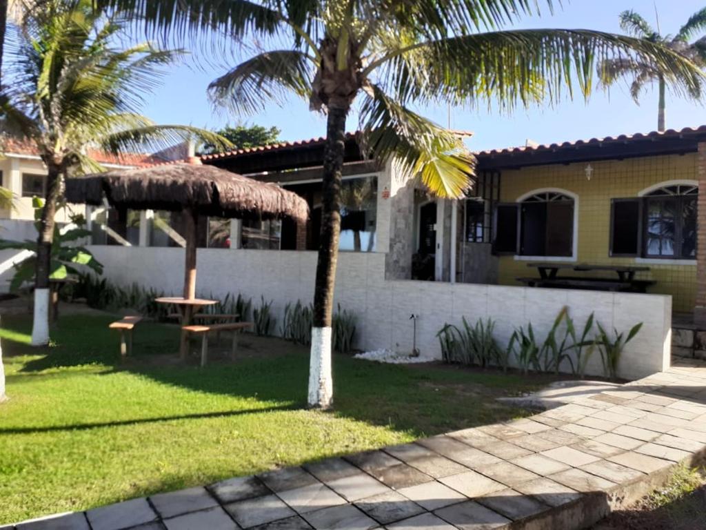a house with a palm tree and a table at Pousada Robijn in Cabo de Santo Agostinho
