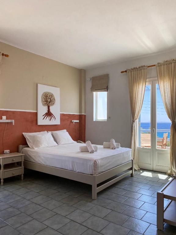 sypialnia z łóżkiem i widokiem na ocean w obiekcie Agnadi Syros Beachfront Studios & Rooms w mieście Megas Gialos - Nites