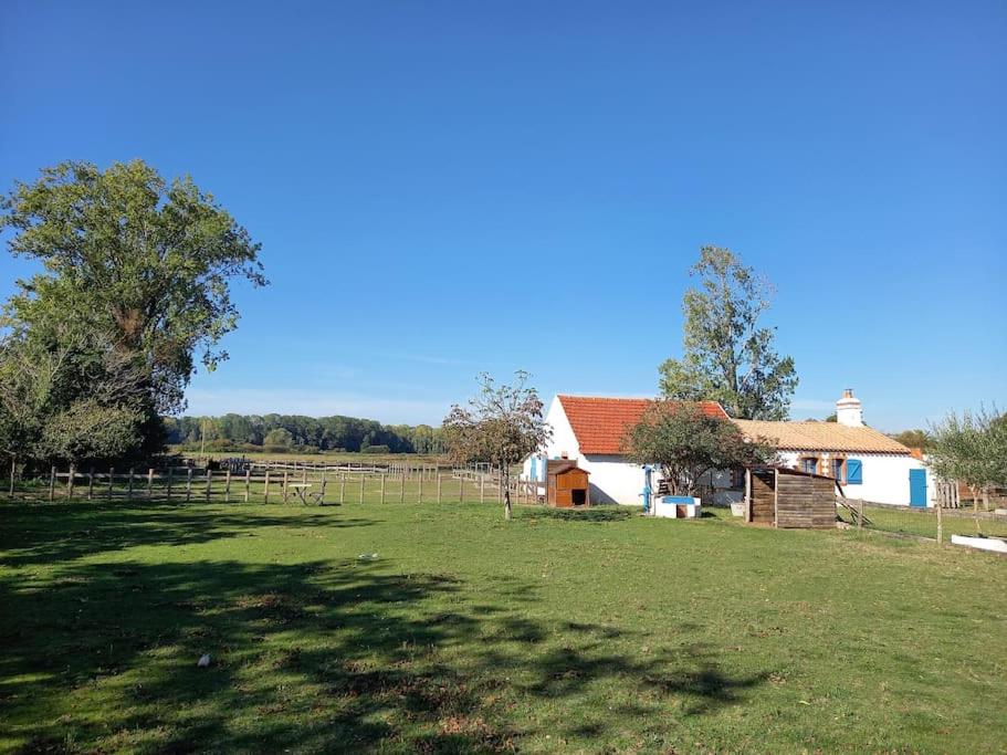 une maison dans un champ à côté d'une clôture dans l'établissement Charmant gîte au cœur de la nature et des animaux, à Saint-Hilaire-de-Riez