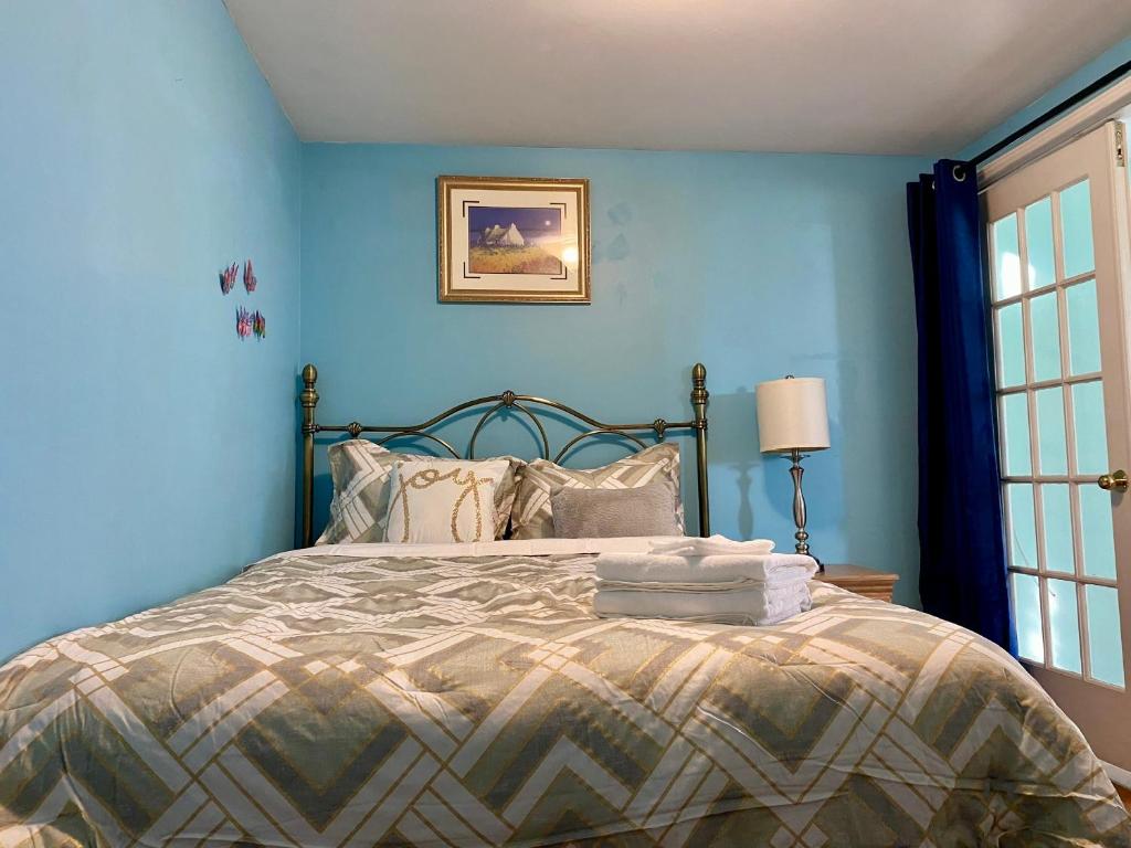 a bedroom with a bed with blue walls at Ozone Homes-Private Basement Unit in Halifax