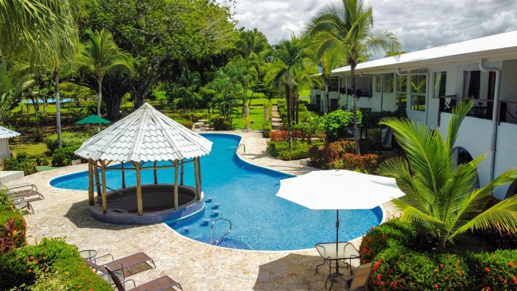 einen Pool mit Pavillon und Stühlen sowie ein Gebäude in der Unterkunft Poolside Oasis near Manuel Antonio! AC/WiFi/Tennis in Quepos