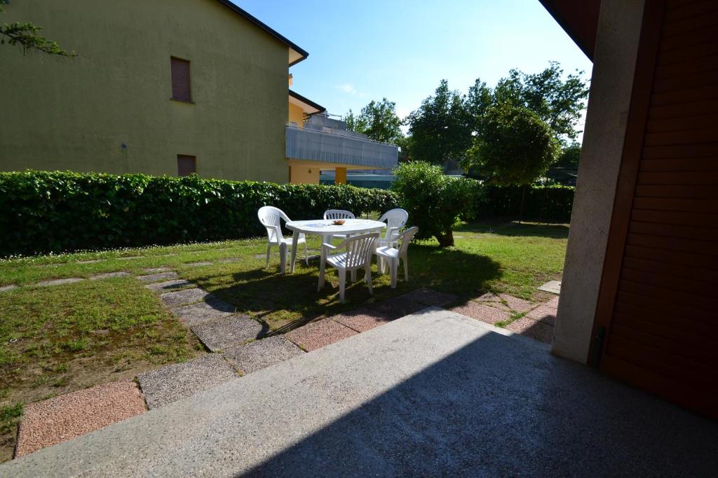 a patio with a table and chairs in a yard at Raffaella in Bibione